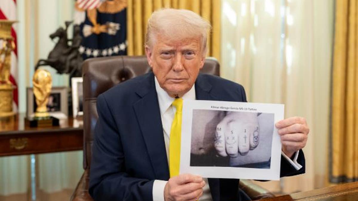 Trump showing photo of tattoos on knuckles of deportee