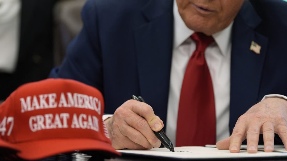 President Donald Trump signs an executive order in the Oval Office of the White House, Wednesday, April 23, 2025, in Washington. (AP Photo/Alex Brandon)