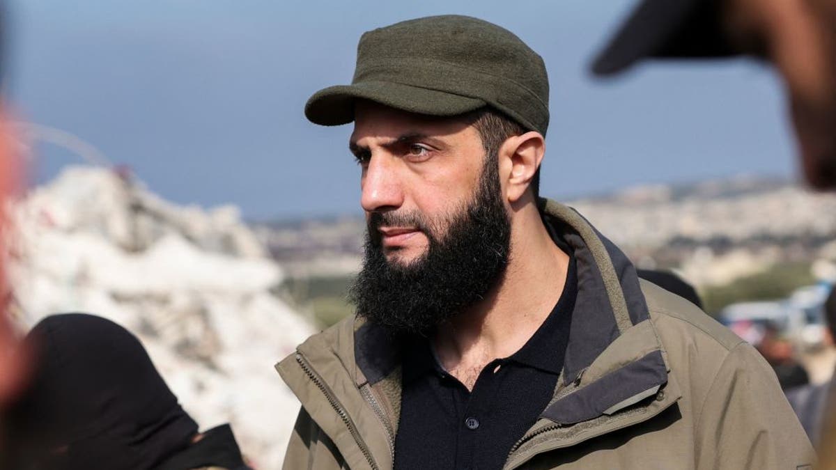 Hayat Tahrir al-Sham, then jihadist group's chief Abu Mohamed al-Jolani, checks the damage following an earthquake in the village of Besnaya in Syria's rebel-held northwestern Idlib province at the border with Turkey, on February 7, 2023. Since becoming the country's leader, Jolani is now known as Ahmad al-Sharaa. 