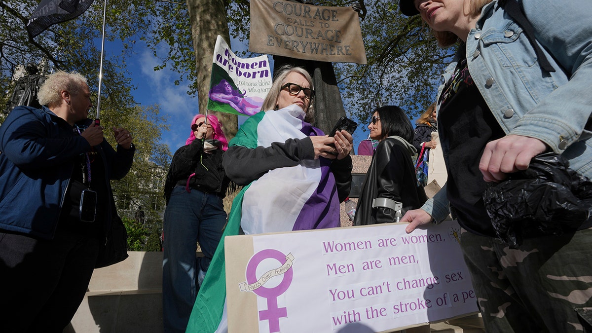 Women's rights activists hold signs outside court