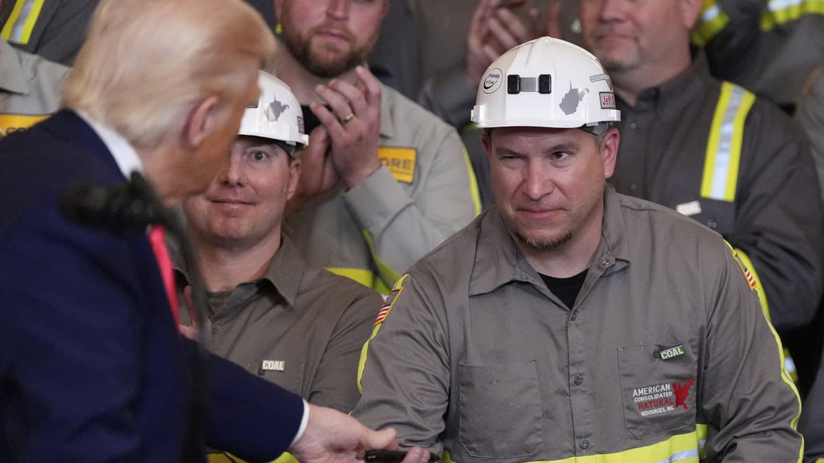 Coal miner Jeff Crowe winks at President Donald Trump after he signed Crowe's speech during an event on energy production in the East Room of the White House, Tuesday, April 8, 2025, in Washington. 