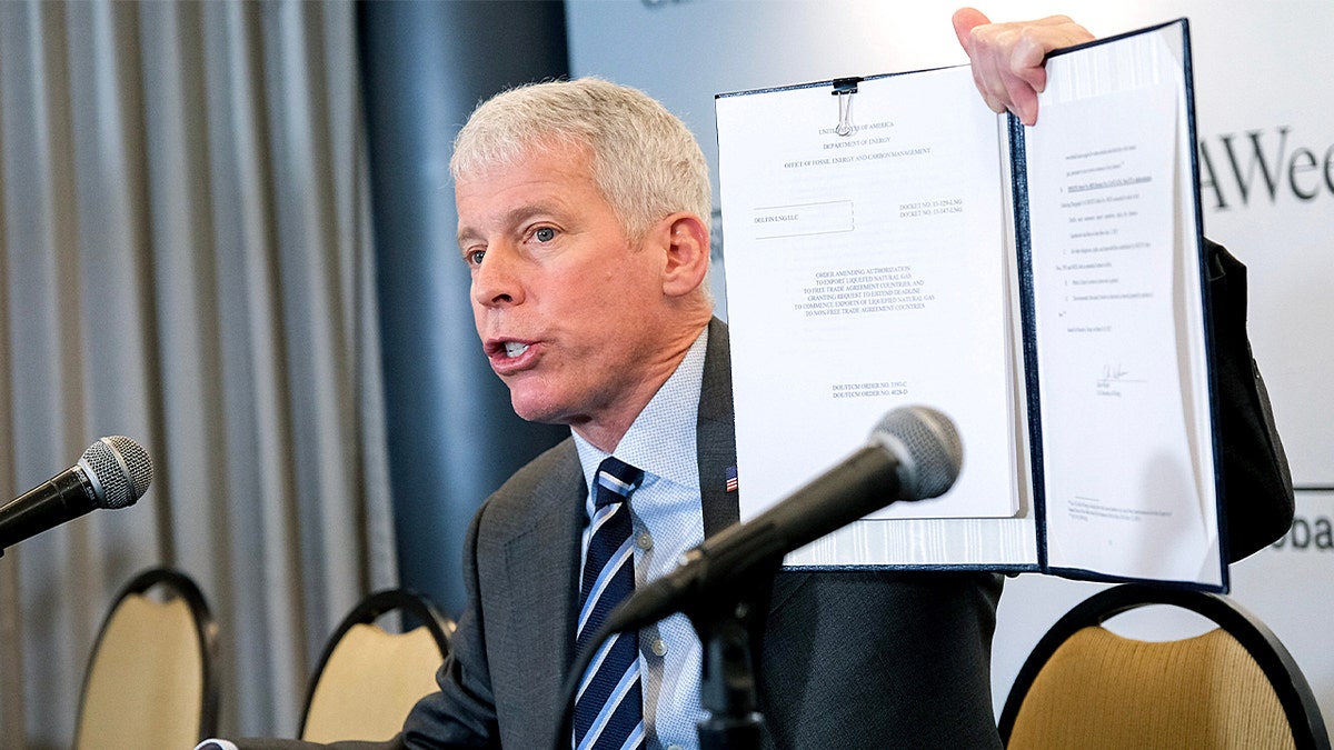 Chris Wright, secretary of energy, displays a signed order approving an LNG permit extension for the Delfin LNG project on the Louisiana coast.