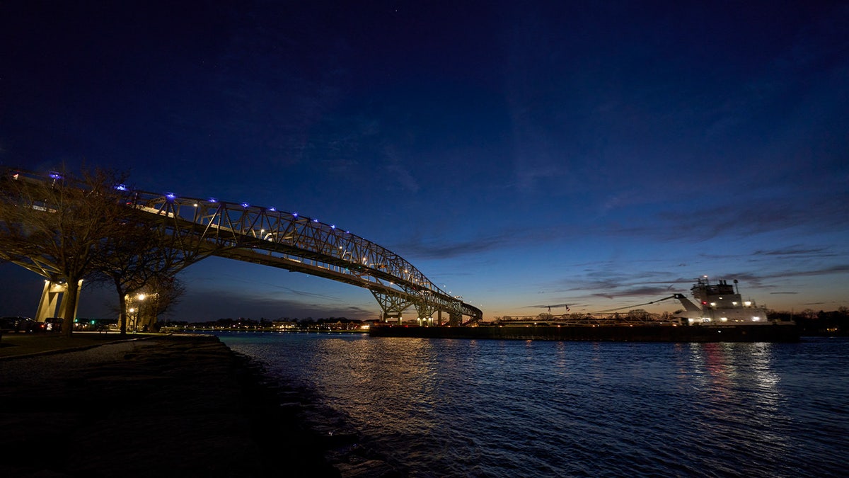 A ship sails down the St. Clair River under the Blue Water Bridge 
