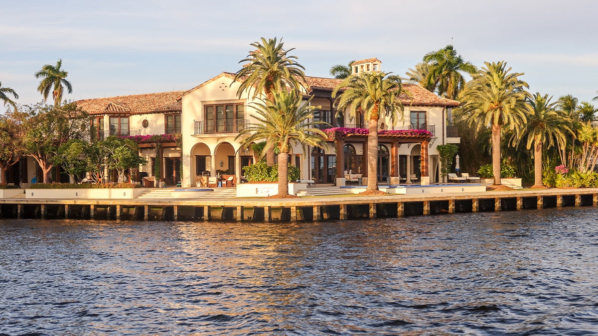 Intercoastal waterway in Fort Lauderdale, Florida. Palm trees, Mediterranean-styled mansion with pink flowers