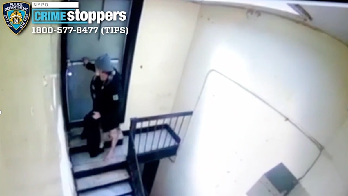 Oswaldo Ramos attempts to open a stairwell door, partially clothed, after an alleged attempted rape in a Bronx apartment building.