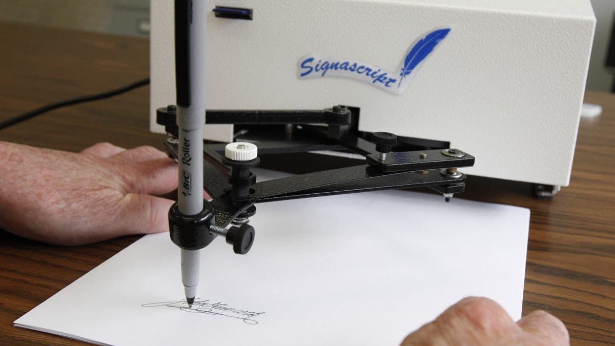 An autopen is a machine that physically holds a pen and replicates someone's signature.