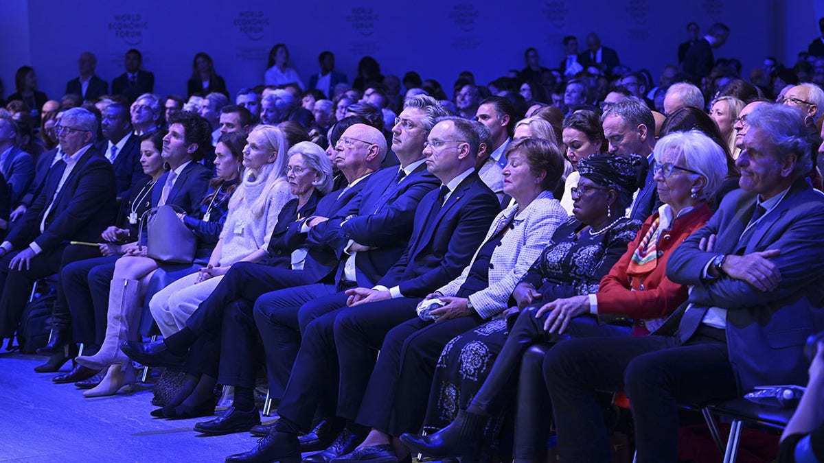Davos meeting participants listen to Trump speech