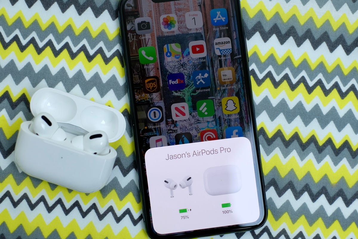 The AirPods Pro next to an iPhone that shows the amount of battery charge for the headphones