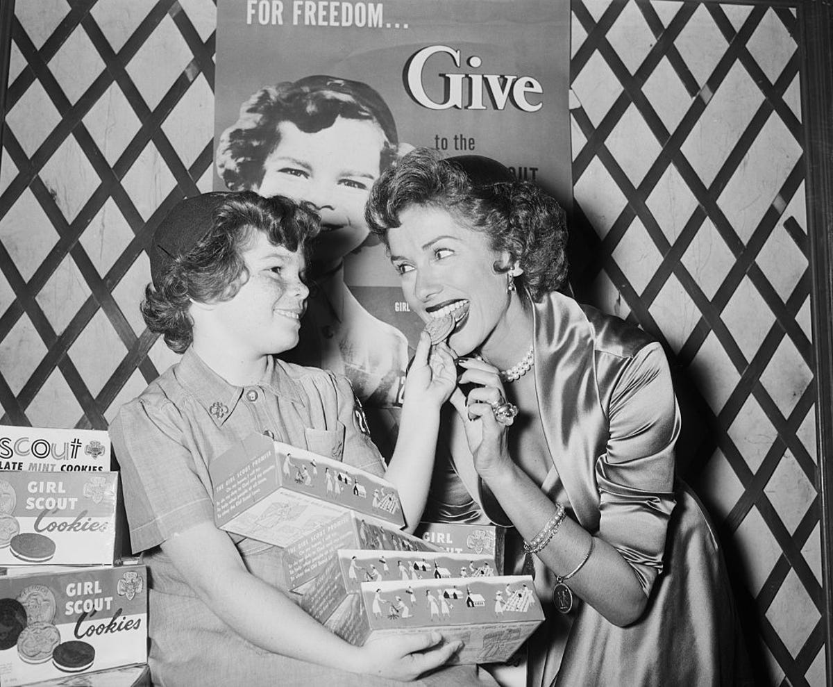 A woman tasting a Girl Scout cookie in 1953.