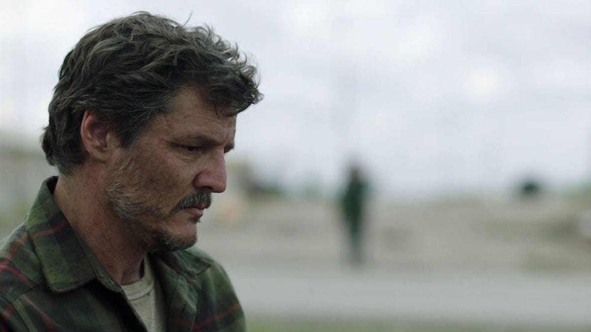Pedro Pascal as Joel in The Last of Us gazes downward while standing outside