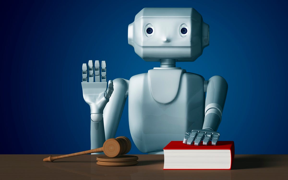A robot places his hand on a book, presumably swearing to tell the truth, and holding his other hand above a gavel.