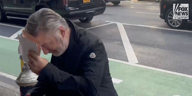 Alec Baldwin holds up an envelope to his face as he enters a building in New York City on Jan. 20, 2023. This is the first time Alec Baldwin was seen since being charged with involuntary manslaughter, following the fatal shooting of cinematographer Halyna Hutchins on the set of Rust in 2021.