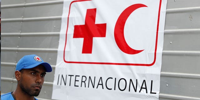 A worker of Venezuelan Red Cross walks past a truck with the logo of the International Federation of Red Cross and Red Crescent Societies in Caracas, on April 16, 2019.