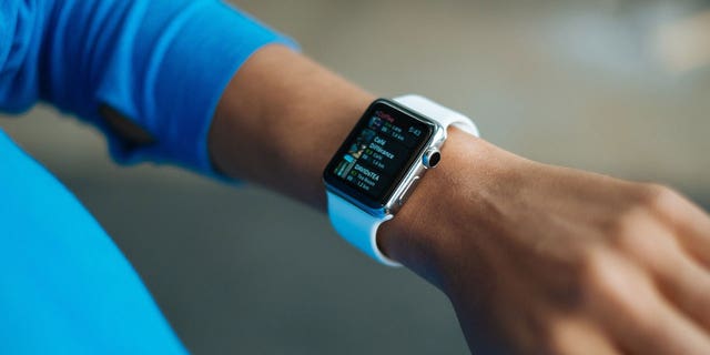 A woman wearing an Apple Watch and looking at places to buy coffee.