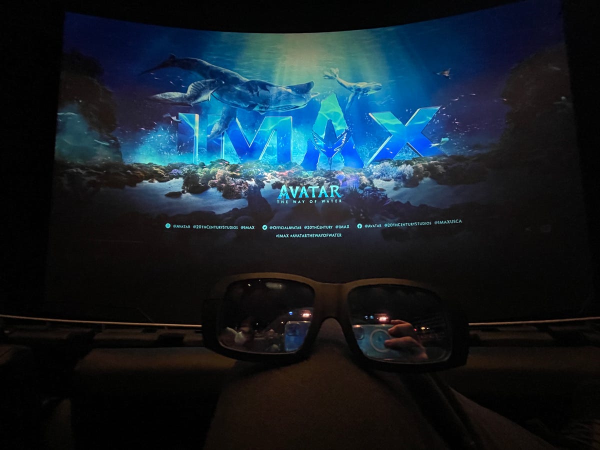 An Imax screen showing Avatar: The Way of Water, with 3D glasses in the foreground