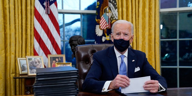President Biden pauses as he signs his first executive orders at the White House Jan. 20, 2021.