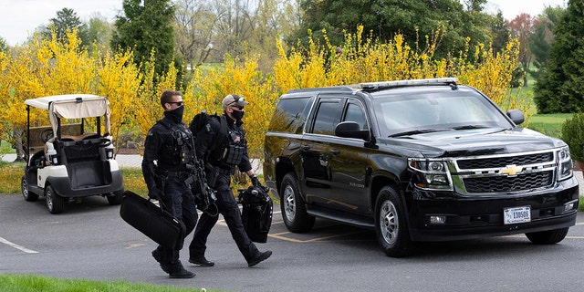 Secret Service officers walk the course as President Biden plays a round of golf at Wilmington Country Club in Wilmington, Delaware, on April 17, 2021.