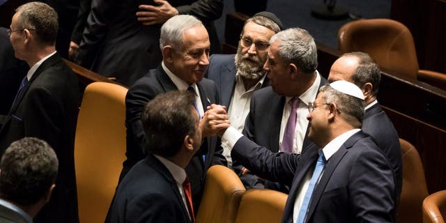 Israeli Prime Minister Benjamin Netanyahu and Minister of National Security Itamar Ben-Gvir react after sworn in at the Israeli parliament during a new government sworn in discussion at the Israeli parliament on Dec. 29, 2022 in Jerusalem.