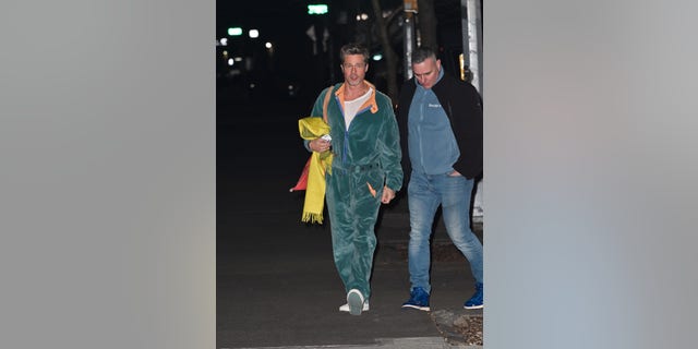 Brad Pitt was also seen in a teal velour jumpsuit. He wore a white shirt underneath with white sneakers and carried a yellow scarf with a red bag over his shoulder.