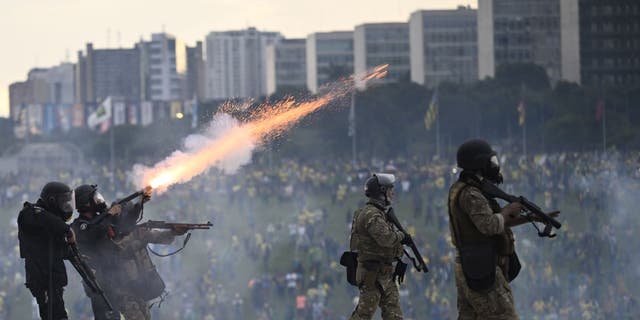 Supporters of former President Jair Bolsonaro supporters clash with security forces as they raid the National Congress in Brasilia, Brazil, 08 January 2023. Groups shouting slogans demanding intervention from the army broke through the police barrier and entered the Congress building, according to local media. Police intervened with tear gas to disperse pro-Bolsonaro protesters. Some demonstrators were seen climbing onto the roofs of the House of Representatives and Senate buildings. 