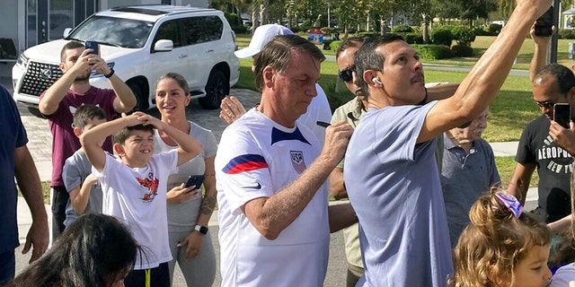 FILE: Former Brazil President Jair Bolsonaro, center, meets with supporters outside a vacation home where he is staying near Orlando, Fla., on Wednesday, Jan. 4, 2023.