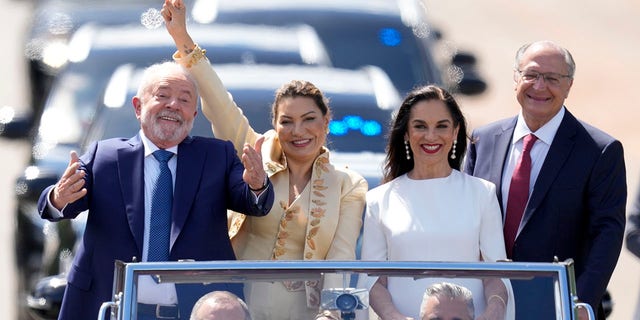 President-elect Luiz Inacio Lula da Silva, left, his wife Rosangela Silva, second from left, Vice President-elect Geraldo Alckmin, right, and his wife Maria Lucia Ribeiro, ride on an open car to Congress for their swearing-in ceremony, in Brasilia, Brazil, Sunday, Jan. 1, 2023. 