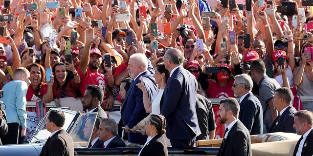 President Luiz Inacio Lula da Silva, right, Vice President Geraldo Alckmin, left, and his wife Maria Lucia Ribeiro, center, ride on an open car to the Planalto Palace in Brasilia, Brazil, Sunday, Jan. 1, 2023.