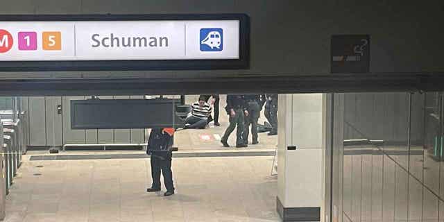 Police surround a man who sits on the floor of a metro station near EU headquarters in Brussels, on Jan. 30, 2023. News reports said that one man was injured in a knife incident around the European Union's headquarters in Brussels before one suspect was detained. The knife attack is not considered to be terrorism.