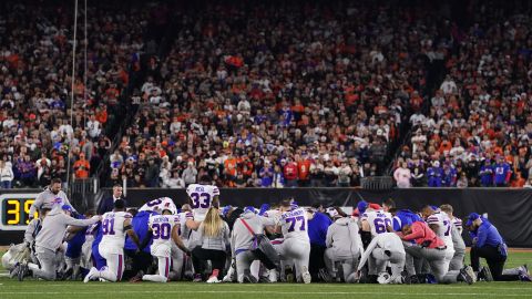 Buffalo Bills players huddle and pray after teammate Damar Hamlin collapsed on the field on Monday.