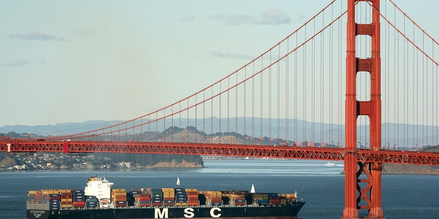 A container ship sails beneath the Golden Gate Bridge as it makes its way into port in San Francisco, California.