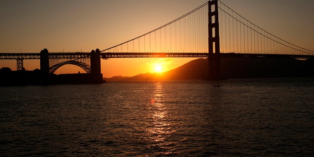 The sun sets near the Golden Gate Bridge before a fireworks show during the 75th anniversary celebration of the iconic span in San Francisco, California May 27, 2012. REUTERS/Robert Galbraith (UNITED STATES - Tags: SOCIETY ANNIVERSARY)