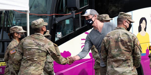 Gov. Gavin Newsom greets members of the National Guard on hand to help out at a mobile testing site in Paramount, California.