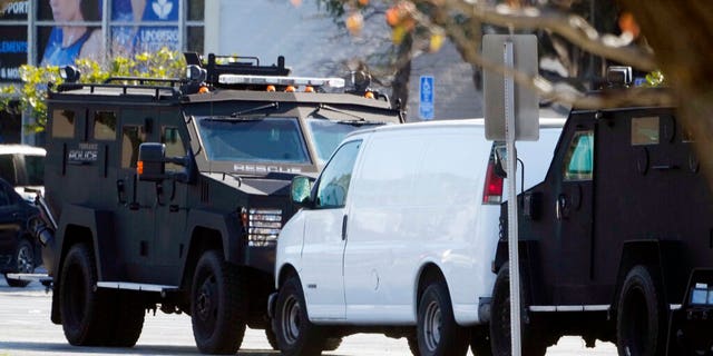 A van is surrounded by SWAT personnel in Torrance Calif., Sunday, Jan. 22, 2023. A mass shooting took place at a dance club following a Lunar New Year celebration, setting off a manhunt for the suspect. (AP Photo/Damian Dovarganes)