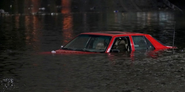 An empty vehicle is surrounded by floodwaters on a road in Oakland, Calif., Wednesday, Jan. 4, 2023. Another winter storm moved into California on Wednesday, walloping the northern part of the state with more rain and snow. It's the second major storm of the week in the parched state. 