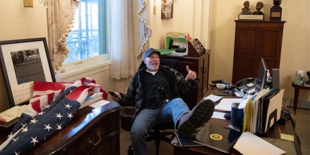 Richard "Bigo" Barnett sits at then-House Speaker Nancy Pelosi's desk in the U.S. Capitol building on January 6, 2021.