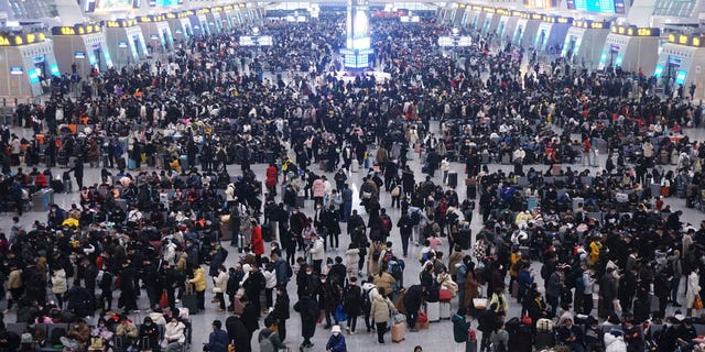 Travelers in China are beginning to crowd transit stations as Lunar New Year festivities begin, with government officials downplaying COVID transmission risks and reporting declining numbers.