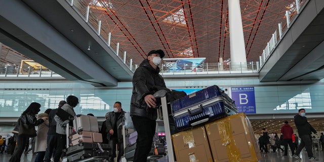 Passengers from Hong Kong arrive at Terminal 3 international arrival hall of the Beijing Capital International Airport in Beijing, Sunday, Jan. 8, 2023. 