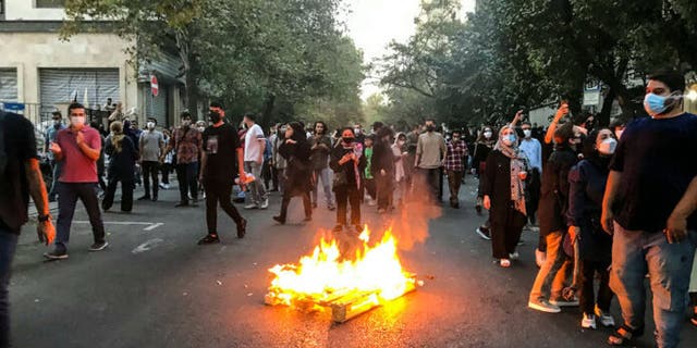 A fire burns on the streets of Iran as protesters continue to chant.