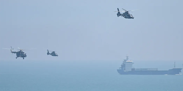FILE: Chinese military helicopters fly past Pingtan island, one of mainland China's closest point from Taiwan, in Fujian province on August 4, 2022, ahead of massive military drills off Taiwan following US House Speaker Nancy Pelosi's visit to the self-ruled island. 