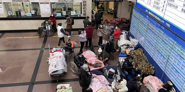Patients lie on beds and stretchers in a hallway in the emergency department of a hospital, amid the coronavirus disease (COVID-19) outbreak in Shanghai, China, January 4, 2023. REUTERS/Staff