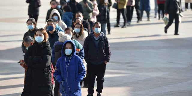 Residents line up outside a pharmacy to buy antigen testing kits for coronavirus, in Nanjing, Jiangsu province, China December 15, 2022. 