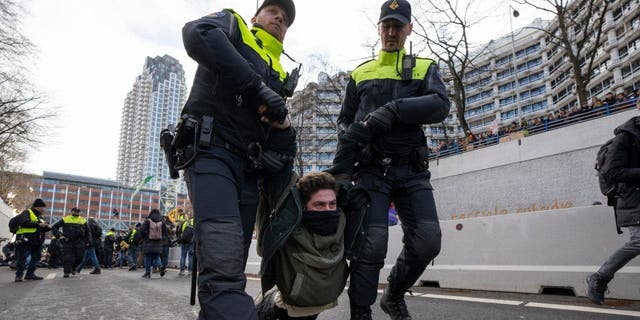 Police detained a protestor after Extinction Rebellion activists and sympathisers blocked a busy road in The Hague, Netherlands, Saturday, Jan. 28, 2023. Earlier this week seven Extinction Rebellion activists were detained by authorities for sedition linked to the protest. 