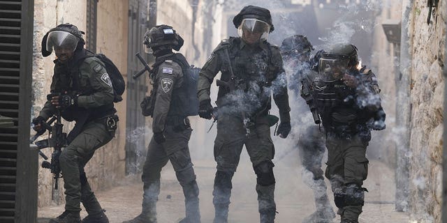 Palestinians shoot fireworks at Israeli police in the Old City of Jerusalem, Sunday, April 17, 2022. Israeli police clashed with Palestinians outside Al-Aqsa Mosque after police cleared Palestinians from the sprawling compound to facilitate the routine visit of Jews to the holy site and accused Palestinians of stockpiling stones in anticipation of violence. 