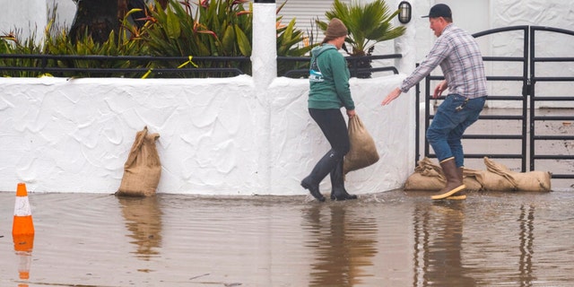 The owners of Venus Pie Trap place sandbags in front of their restaurant in the Rio Del Mar neighborhood of Aptos, Calif., Monday, Jan. 9, 2023. 