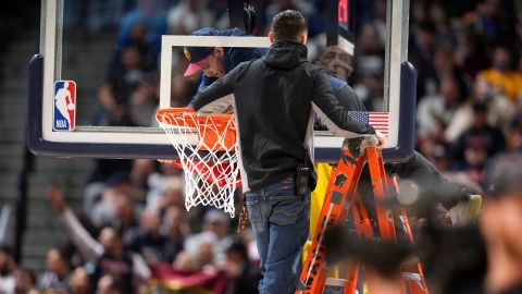 Workers straighten the rim of the basket on Friday. 