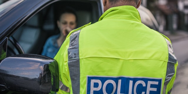 A police officer pulls over a motorist.