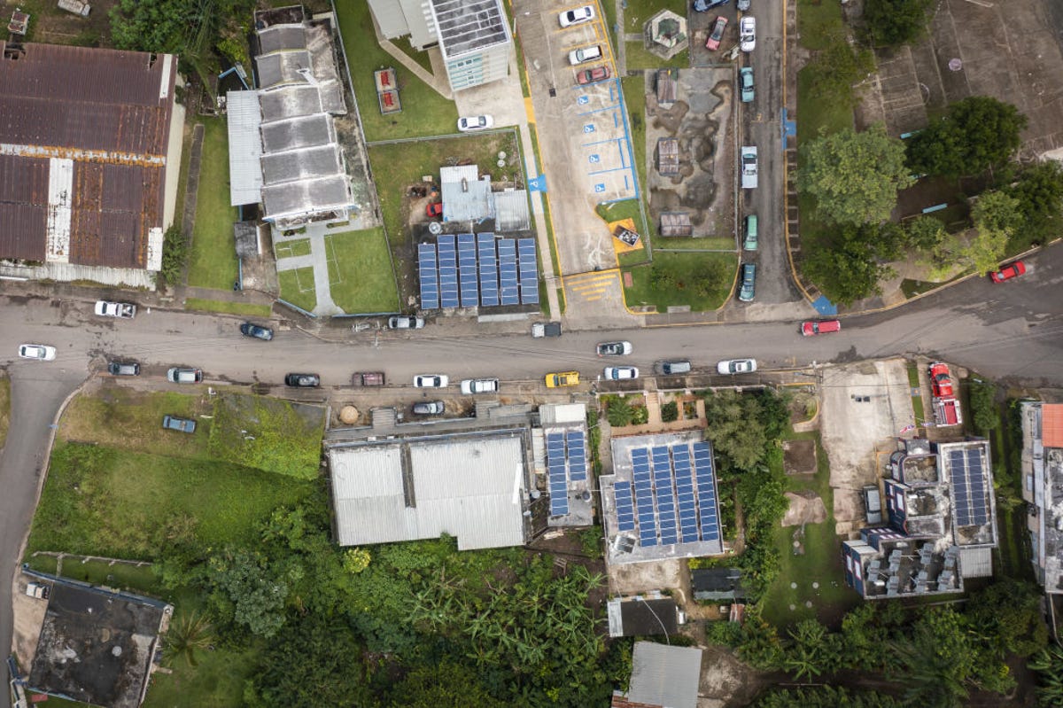 Aerial view of rooftops, some covered with solar panels