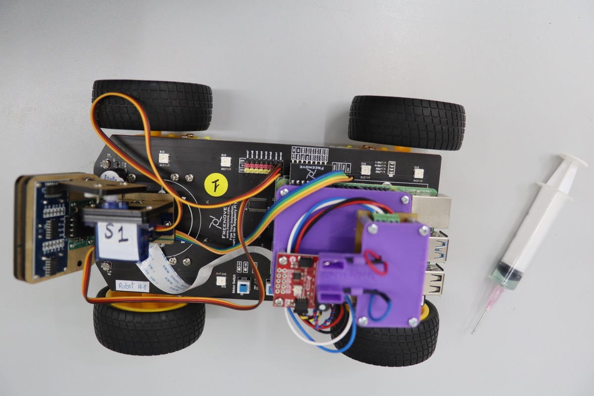 The same robot as in the previous image is seen from a top view. There are some colorful wires, things that look like mechanical chips and other such tech parts.