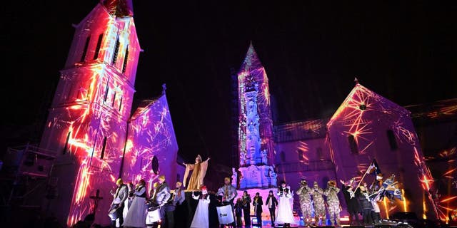 Musicians and dancers perform on stage in front of the light-painted churches in Veszprem, Hungary, during the grand opening on Jan. 21, 2023, as the town and its region became the 2023 European Capital of Culture along with Elefsina, Greece, and Timisoara, Romania.