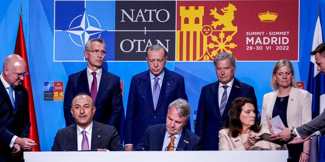 From left to right background: NATO Secretary General Jens Stoltenberg, Turkish President Recep Tayyip Erdogan, Finland's President Sauli Niinisto, Sweden's Prime Minister Magdalena Andersson, Turkish Foreign Minister Mevlut Cavusoglu, Finnish Foreign Minister Pekka Haavisto, and Sweden's Foreign Minister Ann Linde sign a memorandum in which Turkey agrees to Finland and Sweden's membership of the defense alliance in Madrid, Spain on Tuesday, June 28, 2022. 